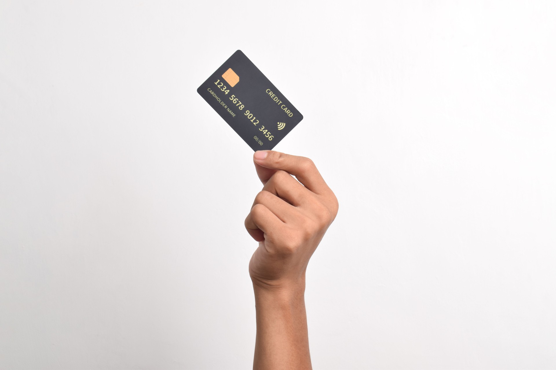 Hand holding credit card on white background